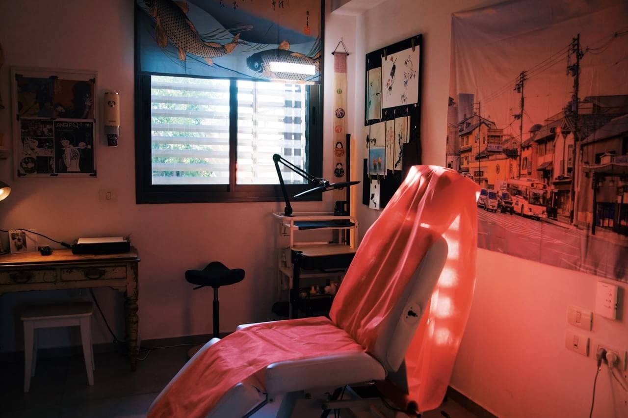 The tattoo chair by the window, with the studio's artwork on the walls