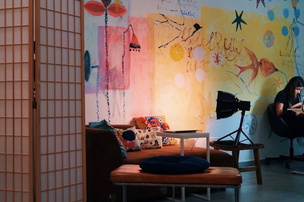 The waiting corner: a folding screen, a low sofa and a painted wall